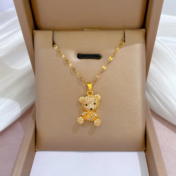 Złoty naszyjnik ze stali chirurgicznej na ozdobnym łańcuszku, z zawieszką w kształcie pluszowego misia w całości wysadzanego jasnymi cyrkoniami z czarnymi detalami.
