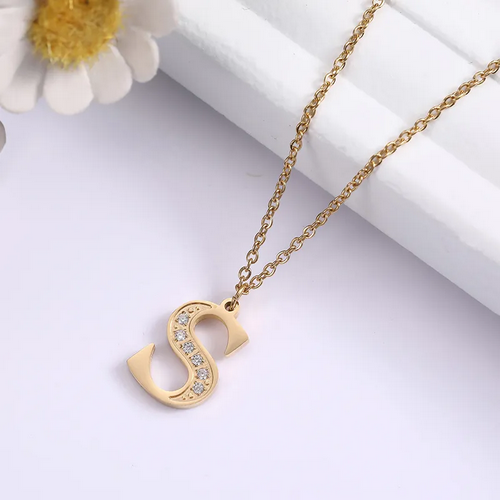 Pozłacany naszyjnik ze stali chirurgicznej. Na delikatnym łańcuszku zawieszono literę alfabetu (inicjał). Połowa literki jest precyzyjnie wysadzana drobnymi, lśniącymi cyrkoniami.