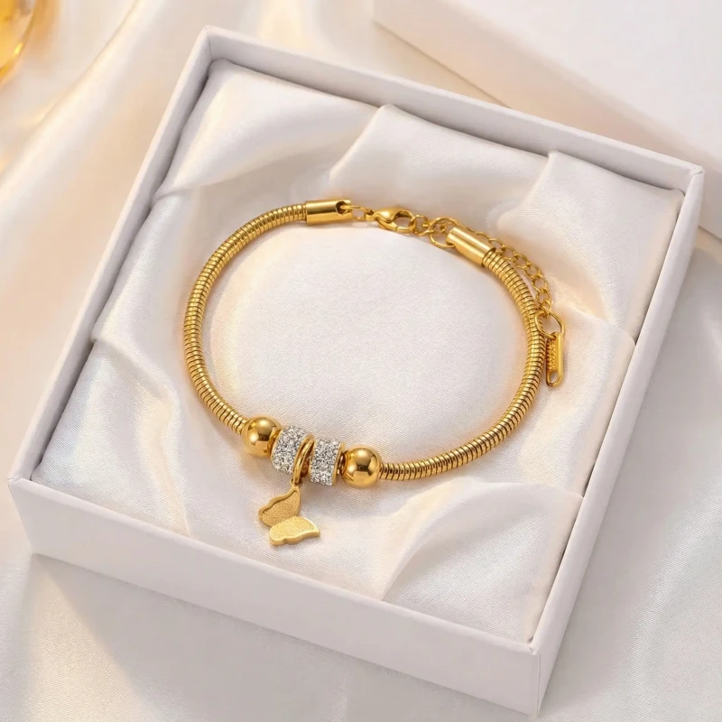 Złota bransoletka ze stali chirurgicznej o splocie pandorka (żmijka) z ozdobnym elementem w kształcie motyla..webp