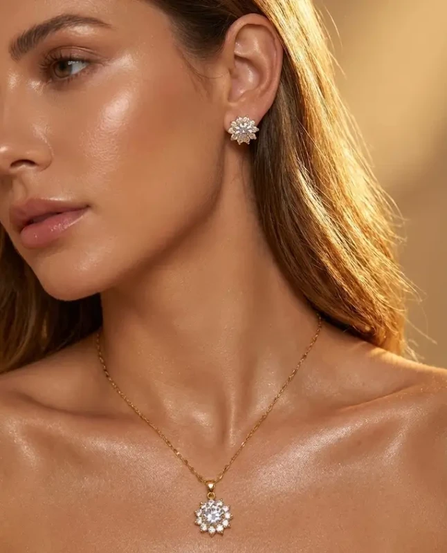 Złoty komplet biżuterii ze stali chirurgicznej (naszyjnik i kolczyki wkrętki) z motywem kwiatowej rozety z dużym centralnym kryształem i cyrkoniami.