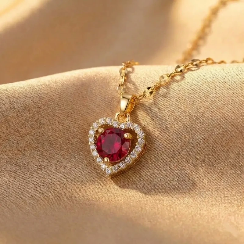 Złoty naszyjnik ze stali chirurgicznej na ozdobnym łańcuszku, z zawieszką w kształcie czerwonego serca otoczonego białymi cyrkoniami.webp