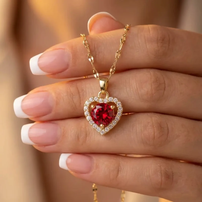 Złoty naszyjnik ze stali chirurgicznej na ozdobnym łańcuszku, z zawieszką w kształcie czerwonego serca otoczonego białymi cyrkoniami.