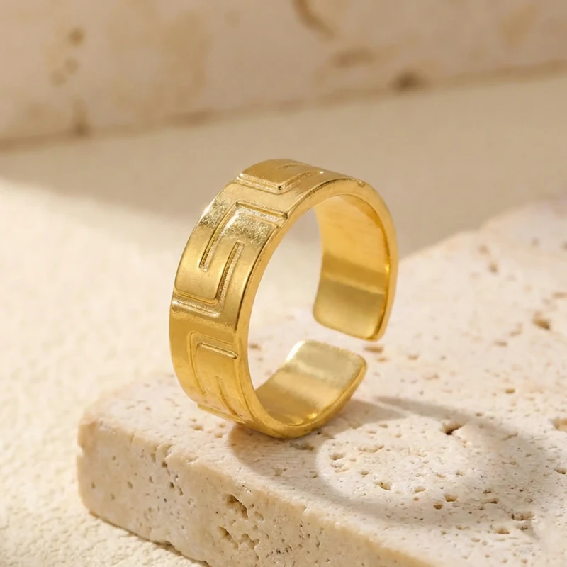 Złoty szeroki pierścionek regulowany ze stali chirurgicznej z tłoczonym wzorem greckim (meander) na obwodzie..webp