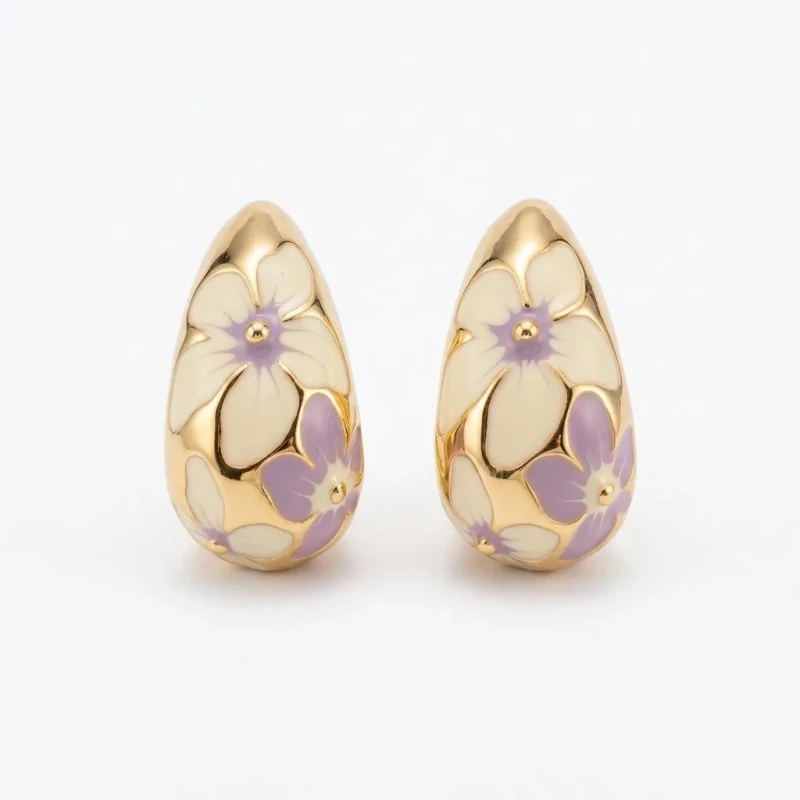 Złote kolczyki o kształcie szerokich półkoli na sztyfcie. Wykonane ze stali chirurgicznej, zdobione jasną emalią z malowniczym motywem kremowych i liliowych kwiatów.