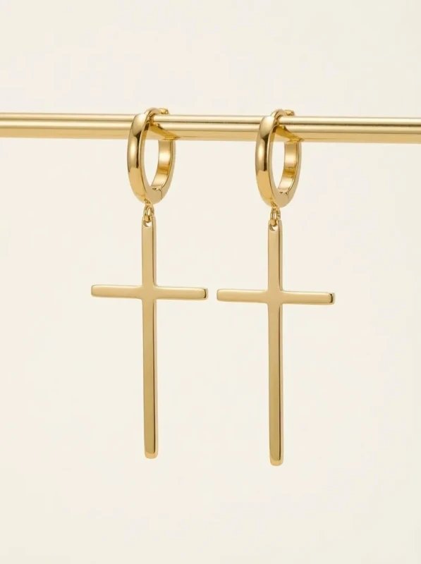 Długie, złote kolczyki wiszące ze stali chirurgicznej. Składają się z małego kółeczka z zapięciem zatrzaskowym, do którego doczepiony jest gładki, podłużny krzyżyk.